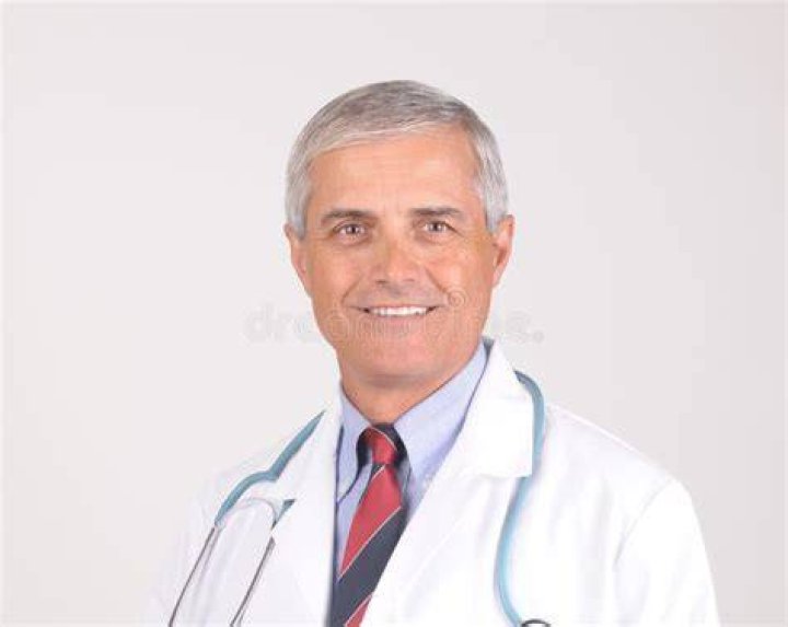 Middle aged doctor with a stethoscope around his neck and holding a